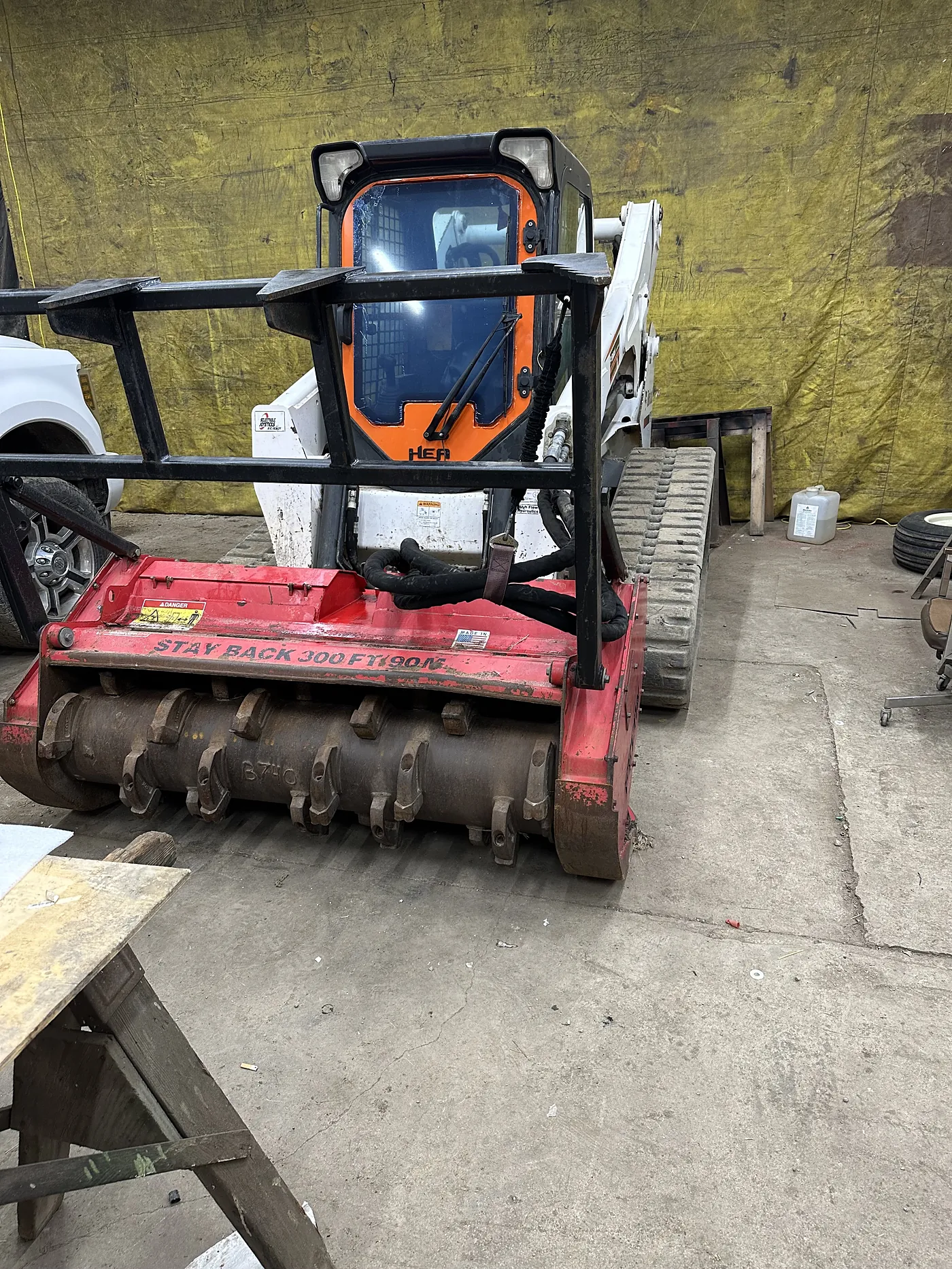 Salz skid steer fitted with a red forestry mulching head